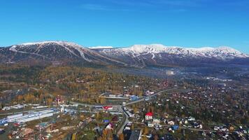 Sheregesh ski resort with snow-covered peaks and autumn valley video