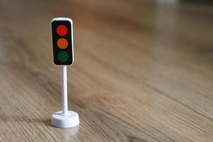 A Miniature Traffic Light Model on a Wood Floor, creating a vibrant and engaging atmosphere photo