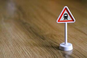 A Miniature Railway Warning Sign displayed prominently on a Wooden Surface for visibility photo
