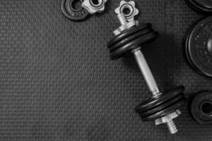 Top view of Iron dumbbells or weights on black floor with copy space for text photo