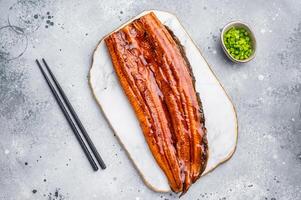 Unagi eel, Japanese grilled fish fillet of eel with sauce. grey background. top view photo