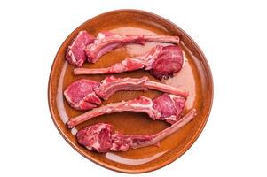 Uncooked lamb chops, fresh mutton meat steaks on a plate isolated on white background. top view photo