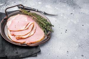 Thinly sliced pork ham, smoked meat. grey background. top view photo