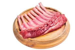 Uncooked rack of lamb, raw mutton chops on wooden board isolated on white background. top view photo
