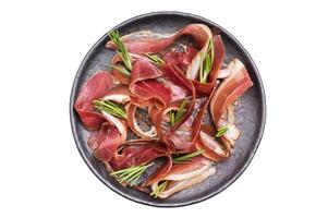 Meat appetizer dried duck breast fillet meat slices, magret smoked poultry isolated on white background. top view photo