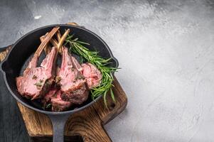Roast lamb chops, mutton meat cutlets in a skillet. grey background. top view photo