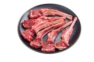 Fresh mutton chops, raw lamb meat cutlets on a plate isolated on white background. top view photo
