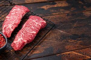 Beef shoulder tender, raw denver steak waiting to be transformed into a gourmet dish. Ideal for grilling or roasting for an unforgettable dinner. wooden background. top view photo