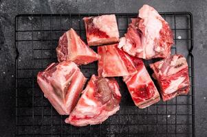 Raw lamb mutton meat and bones for stew or goulash. black background. top view photo