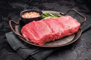A selection of raw bison steaks arranged artfully, emphasizing their quality and texture, inviting culinary creativity in the kitchen. black background. top view photo