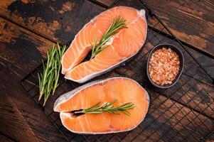 Vibrant raw salmon steak, showcasing its rich color and texture, ideal for sushi or sashimi enthusiasts seeking quality ingredients. wooden background. top view photo