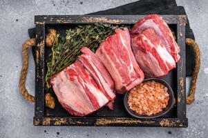 Fresh Raw lamb rib cuts, mutton meat with rib bone in wooden board. grey background. top view photo