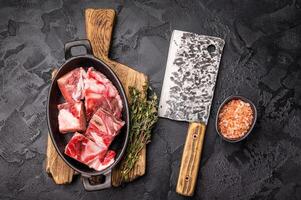 Raw chopped lamb meat with bones, uncooked mutton ready for cooking. black background. top view photo