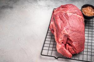 Raw Round beef meat cut, bottom round. grey background. Top view photo