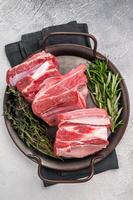 Raw lamb Riblets, fresh mutton meat with rib bone. grey background. top view photo