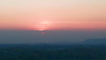 The sky bursts into a breathtaking spectrum of colors as the sun sets behind lush treetops, accompanied by the soft rustling of leaves and the distant sounds of nature winding down for the night. video