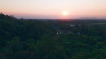 Experience the tranquility of twilight as the sky transitions from deep blue to fiery orange, with trees standing tall as silent witnesses to the beauty of the sunset. video