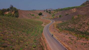 Embark on a journey along a winding road that cuts through the dry, rugged mountains. The curves and barren landscape create a striking contrast video