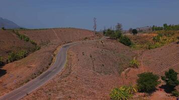 Follow the winding road as it stretches through a vast, dry mountain range. video
