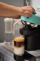 Man using capsule coffee machine with espresso cup. Nespresso is worldwide leader company with coffe machines and capsules. photo