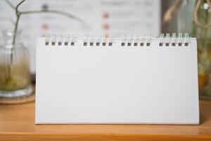 Blank desk calendar on table in mock up and copy space concept photo
