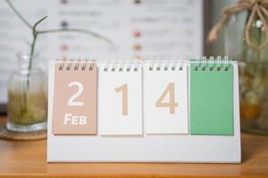 February 14 text on desk carlendar on wooden table. photo