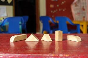 Geometric Wooden Blocks on a Red Table in a Classroom photo
