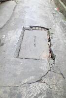 Urban Street with Broken Concrete and Drain photo