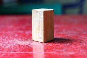 Minimalist Wooden Block on a Textured Red Surface photo
