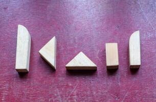 Geometric Wooden Blocks on a Textured Red Surface photo