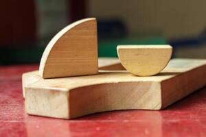 Wooden Geometric Blocks on a Rustic Red Table, Minimalist Still Life photo