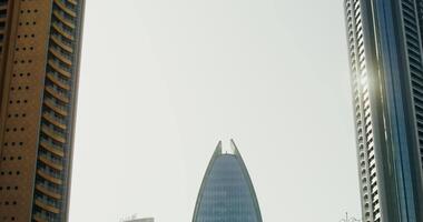 Modern glass skyscrapers of unusual shapes with sunlight reflected in it, a rainbow in the windows video