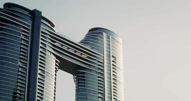 Modern glass skyscrapers of unusual shapes with sunlight reflected in it next to a traditional building requiring restoration video
