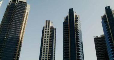 Circular view of glass skyscrapers. Bottom-up view of modern high-rise buildings in daylight video