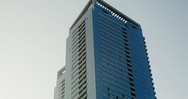 Modern minimalistic glass skyscraper, moving from top to bottom, clear sunny day video
