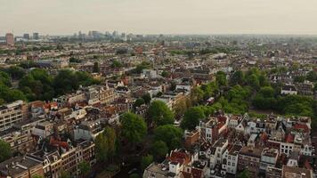 Narrow streets of the historic center of Amsterdam with traditional houses on both sides of the canal. from a bird's eye view, from a drone video