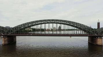Drohne , Aussicht von das Eisenbahn-Fußgänger Brücke im das Stadt von Köln. ein Brücke mit Metall Halbkreise steigend über das Straße, Antenne Aussicht von das Fluss. video