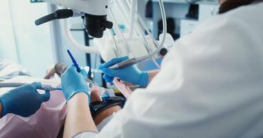 Dental treatment in a modern dental office. Close-up of a patient's face with an open mouth lying in a dental chair, viewed from behind. in 4k, red komodo video