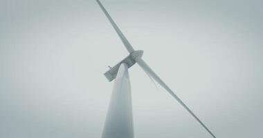 Close-up of the powerful blades of an industrial wind turbine rotating from the wind, viewed from below. There are no people in the . in 4k, red komodo video