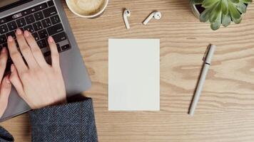 handsome serious man of European appearance with beard, in plaid shirt, makes a pencil drawing in a notebook with a ruler, in a carpentry workshop, filming from behind video