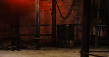 A man in leather boots and an apron walks around the forge, a close-up of male legs. Ashes and coals lie on the floor. in 4k, red komodo video