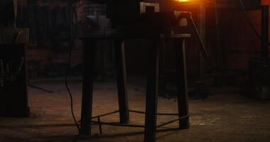 An angle grinder lies on a table in a modern blacksmith's workshop. There are no people in the . 4k , red komodo video