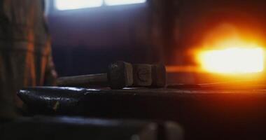 The hammer lies on the anvil in the blacksmith's workshop, close-up, no people. Details of the working process of forging iron. 4k , red komodo video