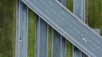 footage from a quadrocopter view of a road bridge over a multi-lane road with passing cars. Multi-level road, top view, filming from a quadrocopter. video