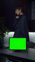 A green screen tablet stands on the desktop of a young businesswoman talking on a mobile phone in the background, chroma key, copy space, mockup. in 4k format, red komodo. video