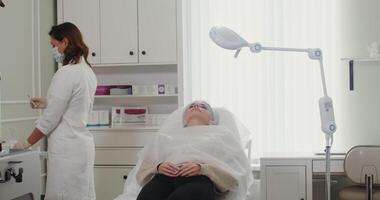 A cosmetologist prepares a syringe with an injection and injects the patient into the skin of the face. Treatment of mimic wrinkles in a modern cosmetology clinic. in 4k, red komodo video