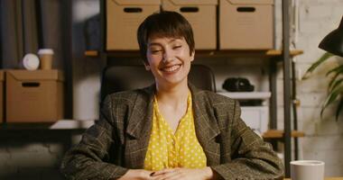 Front camera, a young beautiful woman of European appearance starts a call, greeting and waving in a sign of greeting, looking directly into the camera video