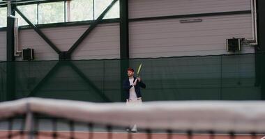A young dark-haired man of European appearance plays big tennis, hitting the ball with a racket over and over again, gracefully bouncing with each racket hit video