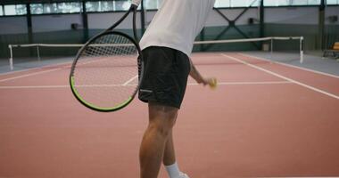 Single training of playing tennis, throwing a tennis ball with a racket over the net, filming from the player's back, close-up video