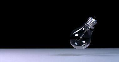 The light bulb falls and does not break, slow motion on a black background video